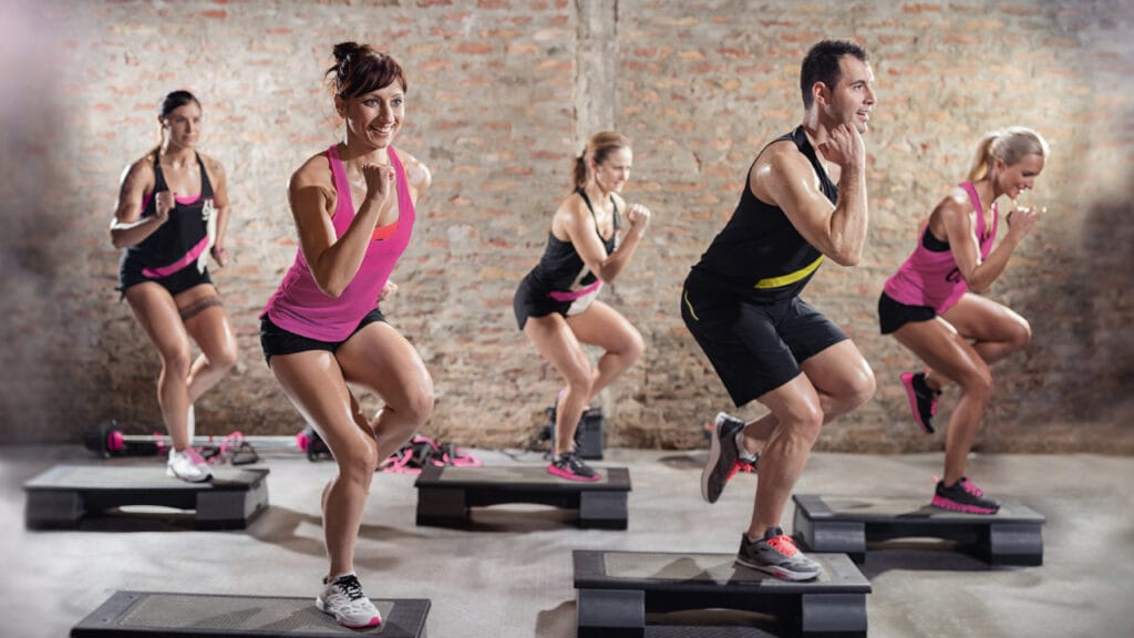 Menschen die den Fitnesskurs Step machen